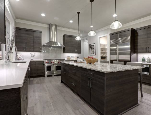 Modern gray kitchen features dark gray flat front cabinets paired with white quartz countertops and a glossy gray linear tile backsplash. Northwest, USA