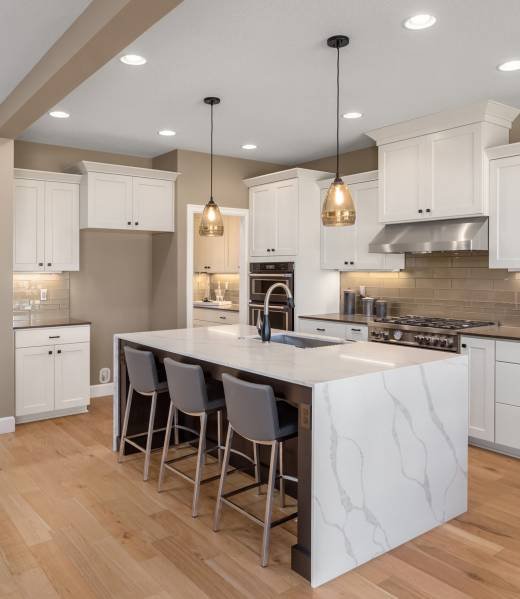 Beautiful kitchen in new luxury home with waterfall island, quar